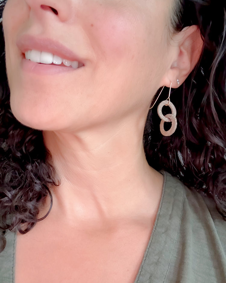Close-up of a woman wearing a double circle earring.