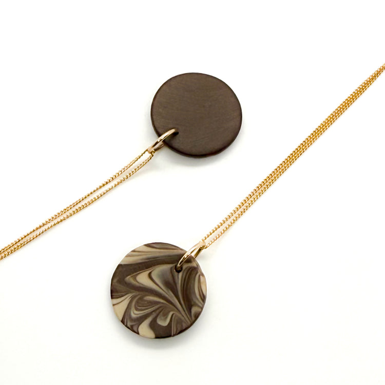 Necklace with marbled disc pendant on a white background