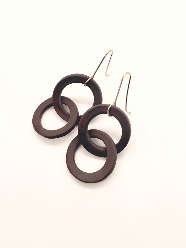 Brown circular earrings on a white background