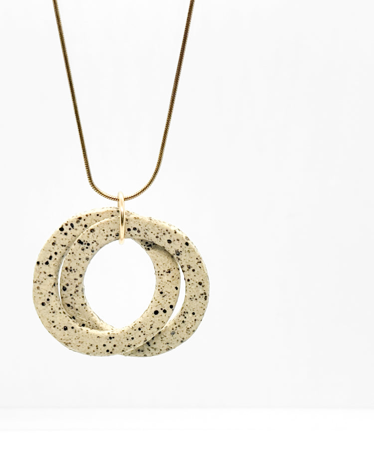 Necklace with a speckled stone pendant on a white background