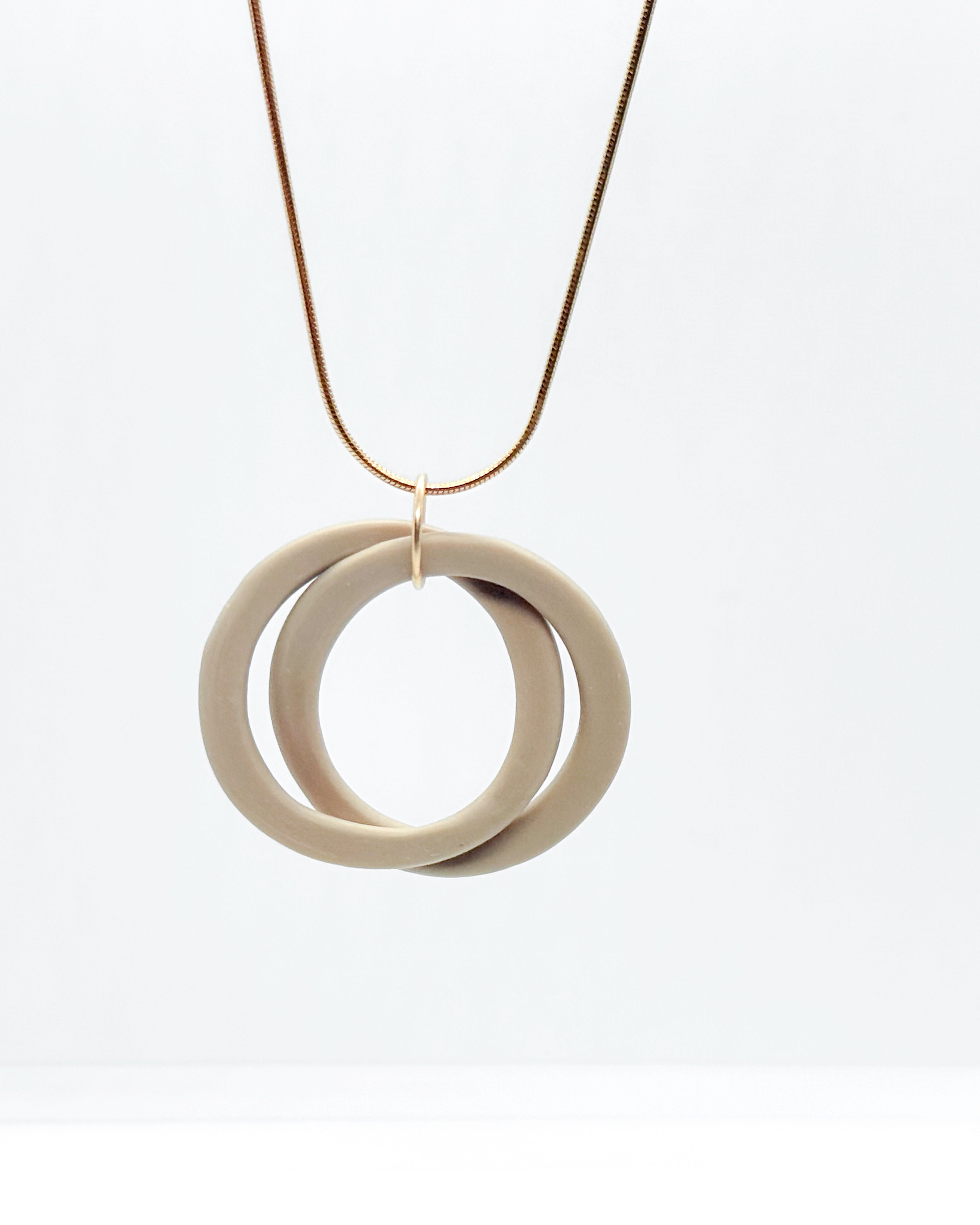 Necklace with two interlocking rings on a white background