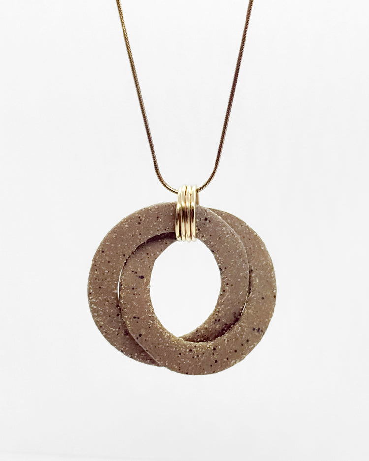 Necklace with two interlocking circular pendants on a white background