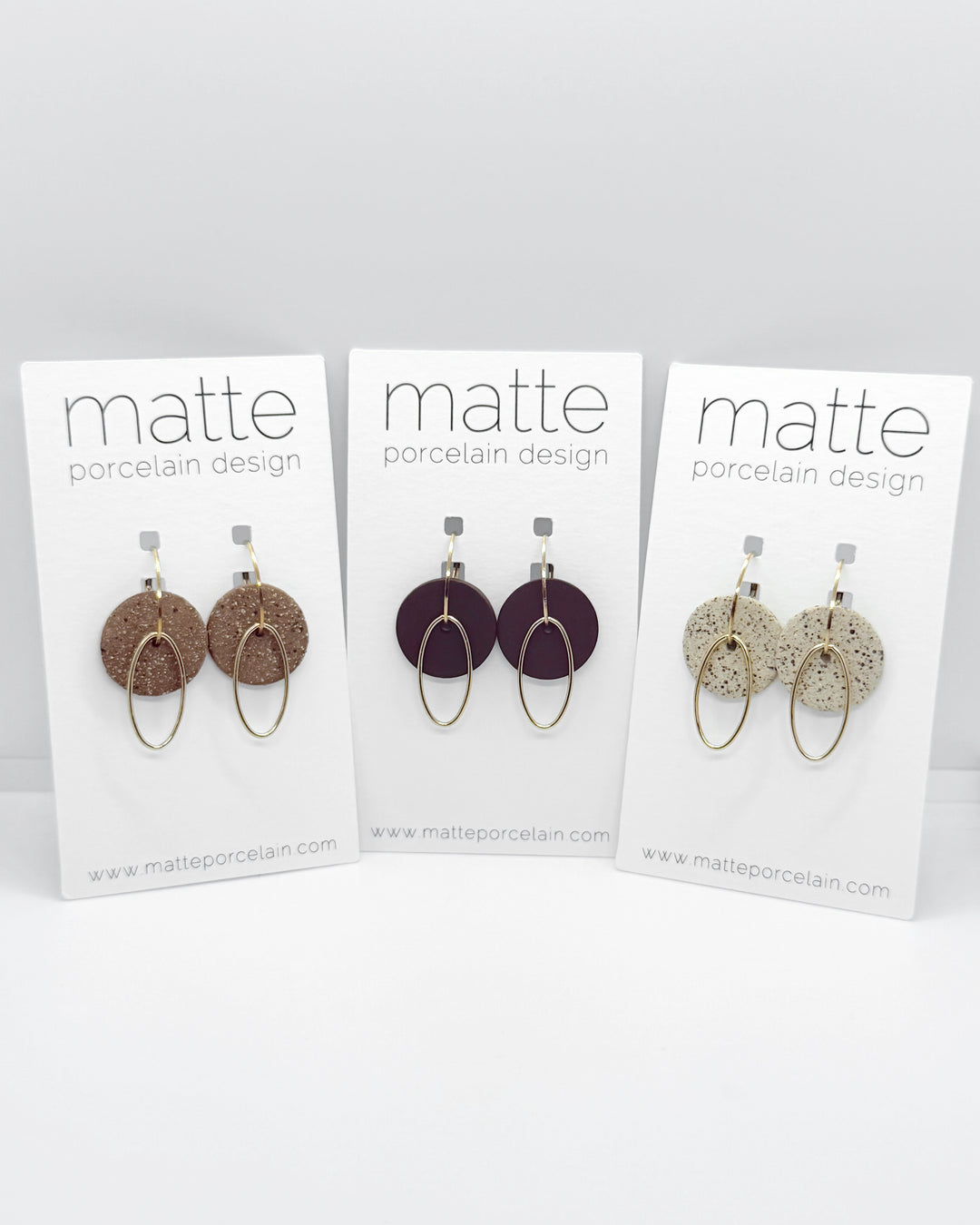 Three cards displaying earrings with 'matte porcelain design' branding on a white background.