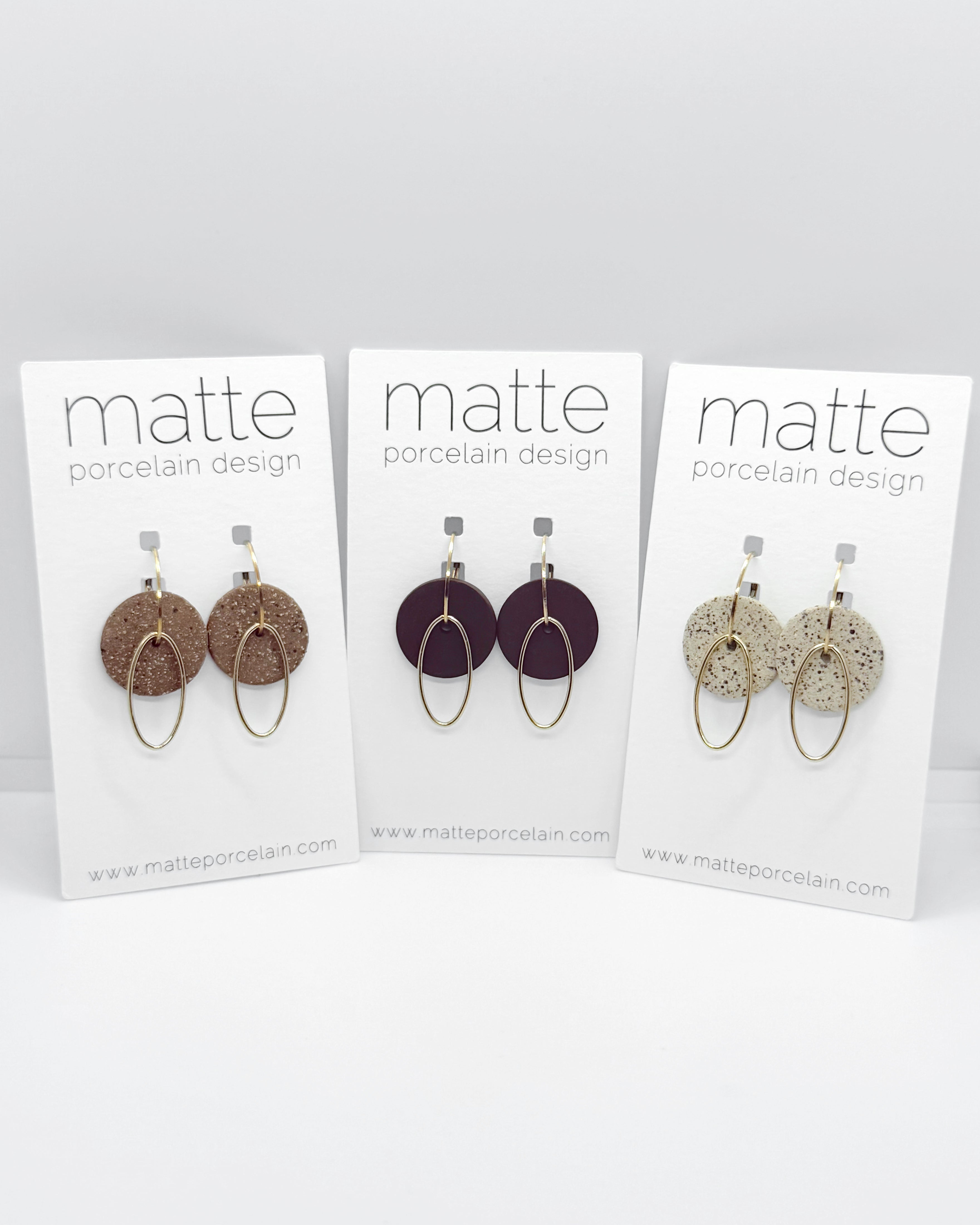 Three cards displaying earrings with 'matte porcelain design' branding on a white background.