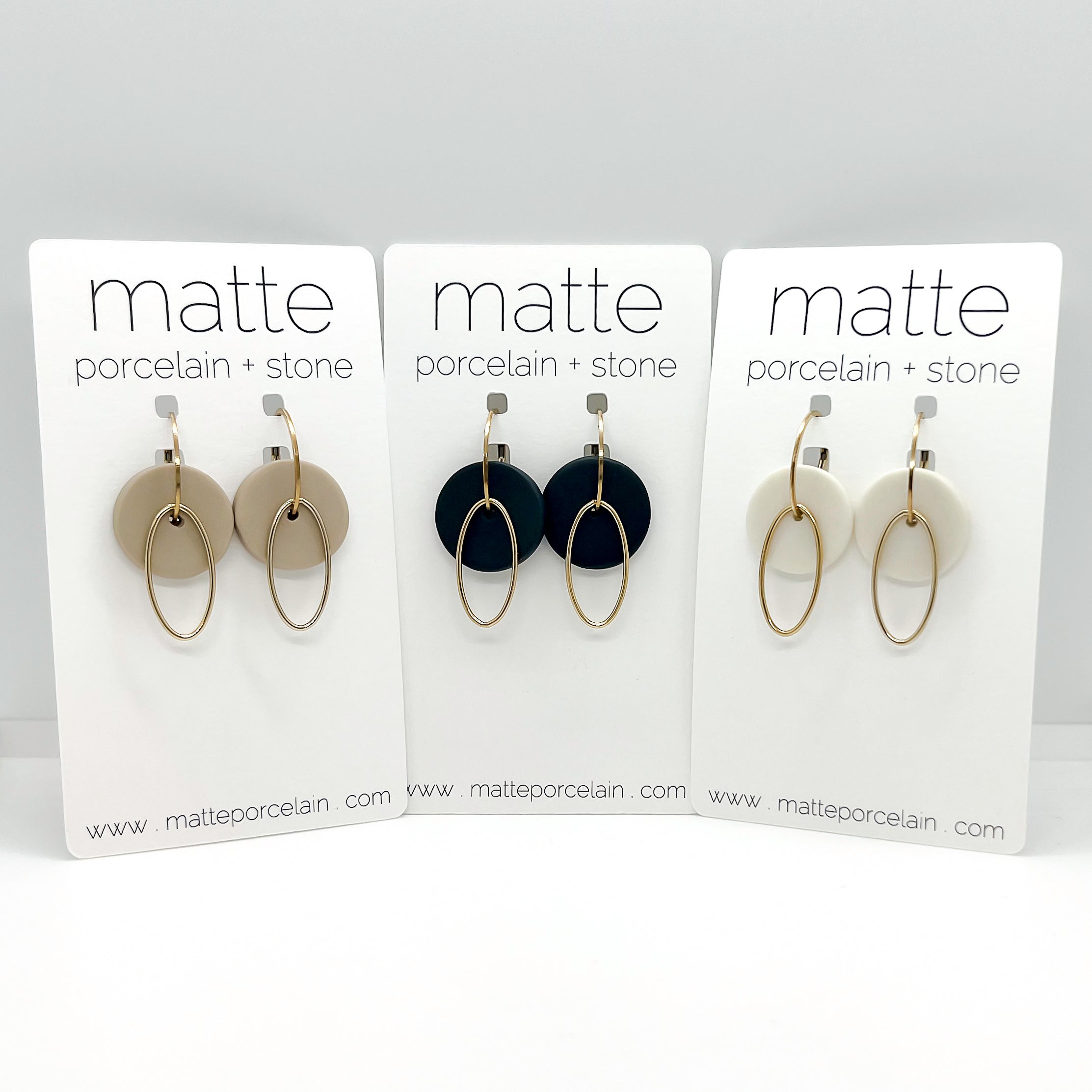 Three sets of earrings on 'matte porcelain + stone' display cards.